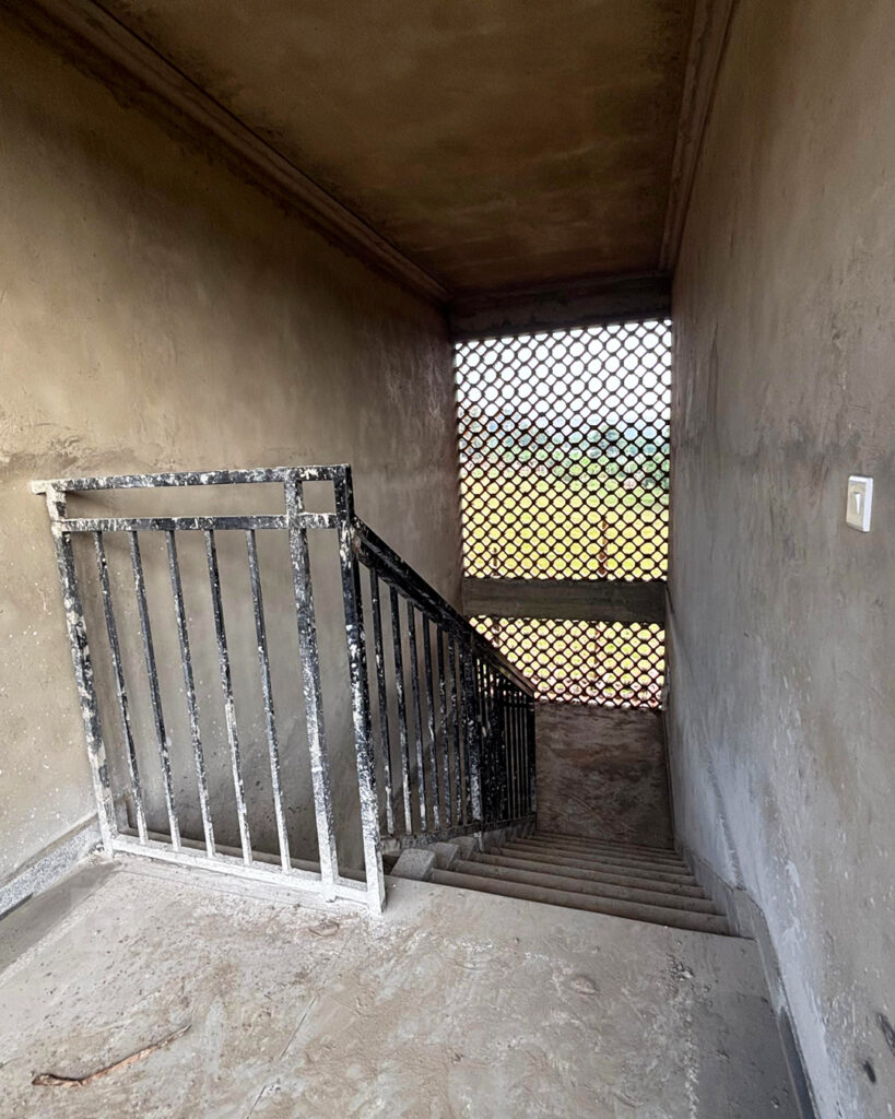 This stairwell is not painted yet but looks pretty because there is a big window where you can see the green fields.