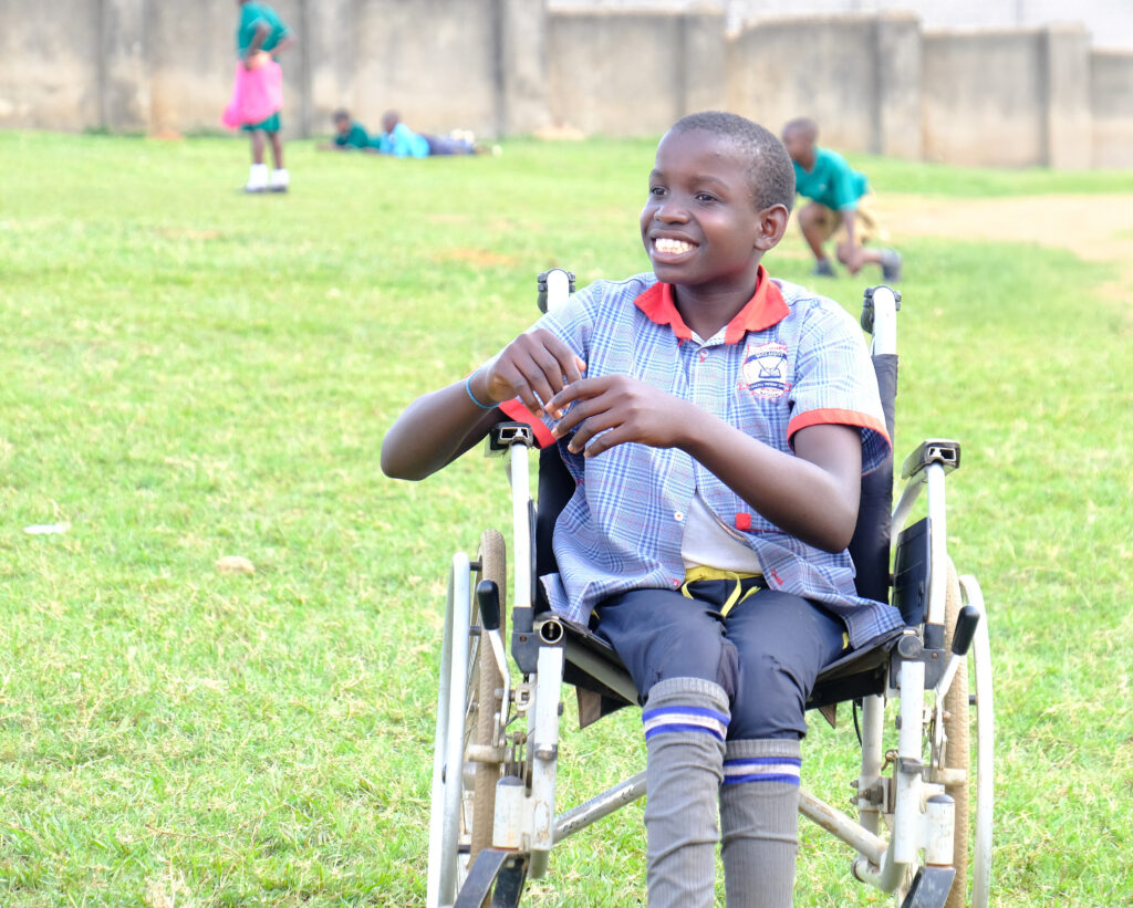 A Ugandan child smiles in his wheelchair at a Sports Festival