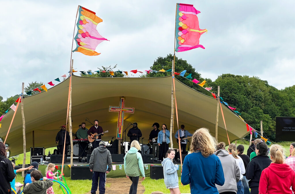Festival stage with singers and very colourful flags blowing in the wind