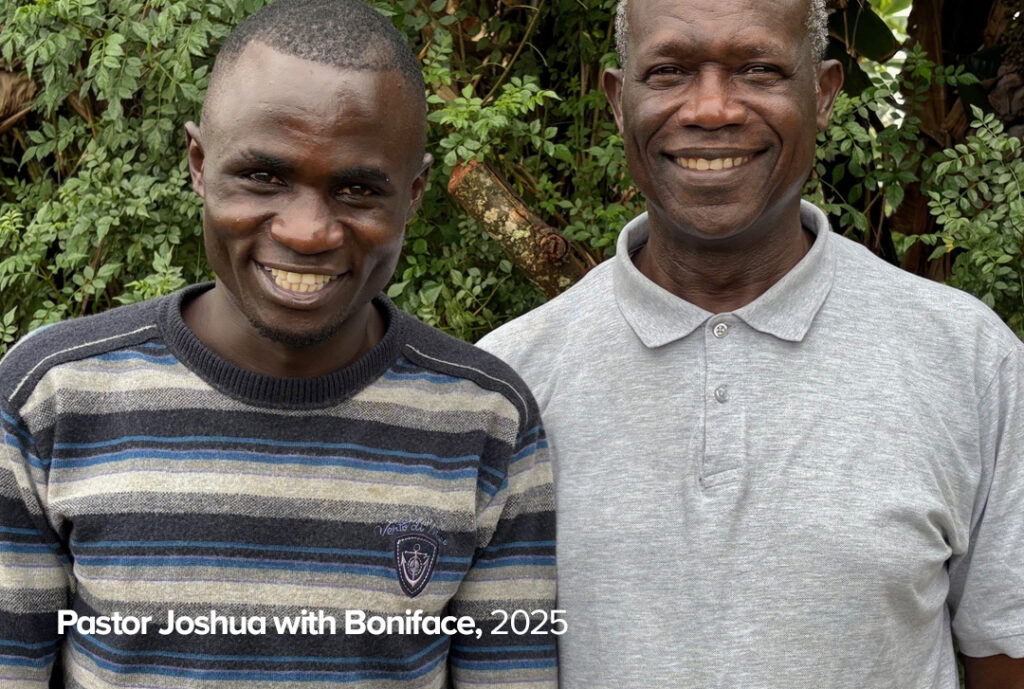 Pastor Joshua and Boniface, who was previously homeless, smiling at the camera