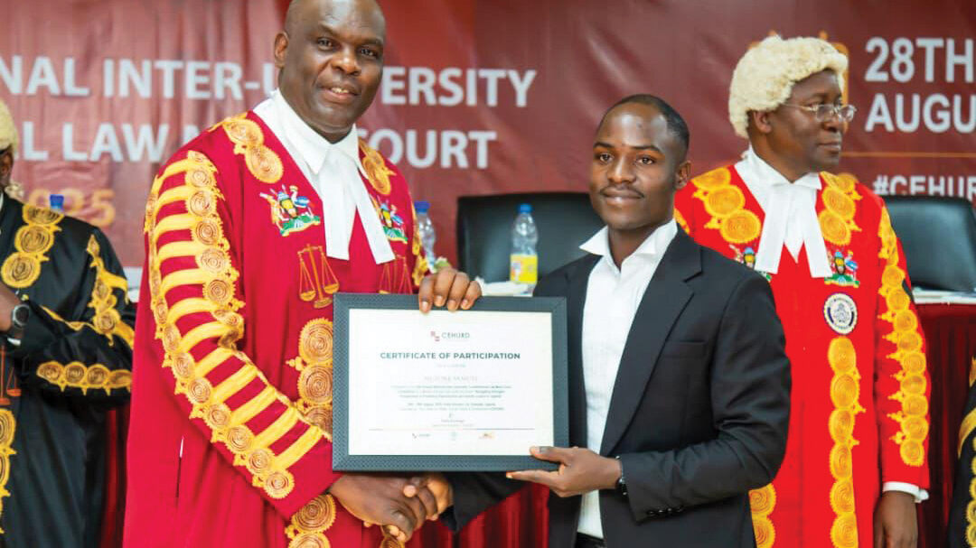 Samuel is holding a certificate while shaking the hand of his professor at Law school