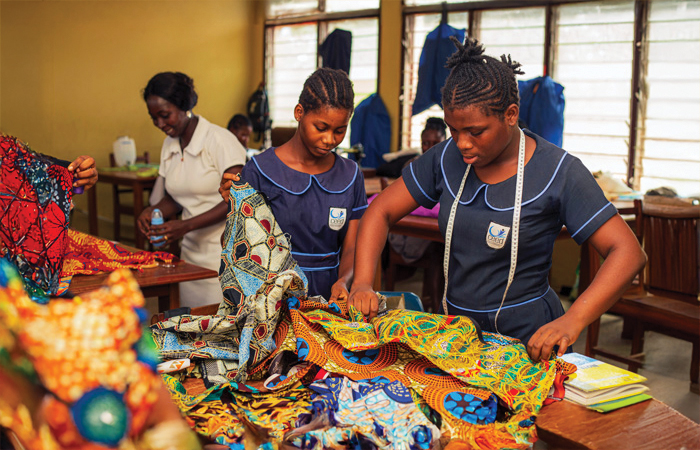 Two students sorting through the scraps of fabric