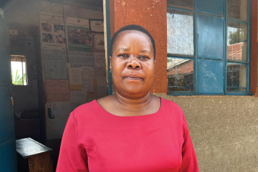 Empowering: a teacher stands outside her classroom in Uganda